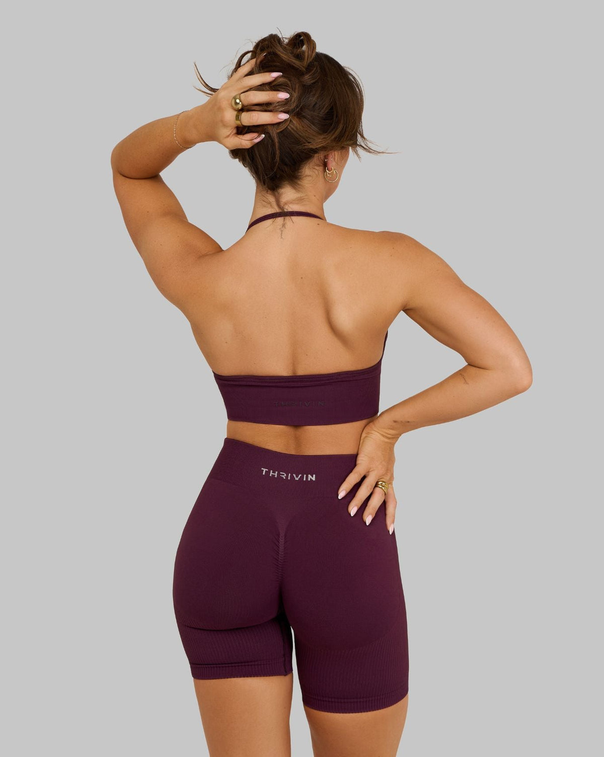Elevate Multiway Sculpt Seamless Bra in Winter Plum Red, back view with arm raised and open halter back