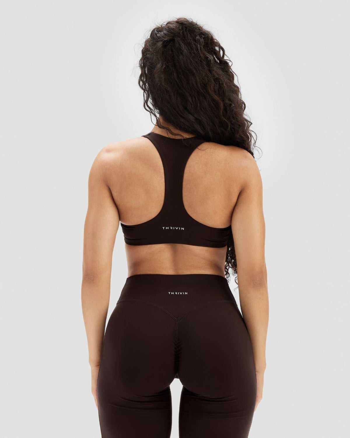 Essence Racer Back Sports Bra in Coffee Brown, back view of racer back with THRIVIN logo, worn with matching leggings