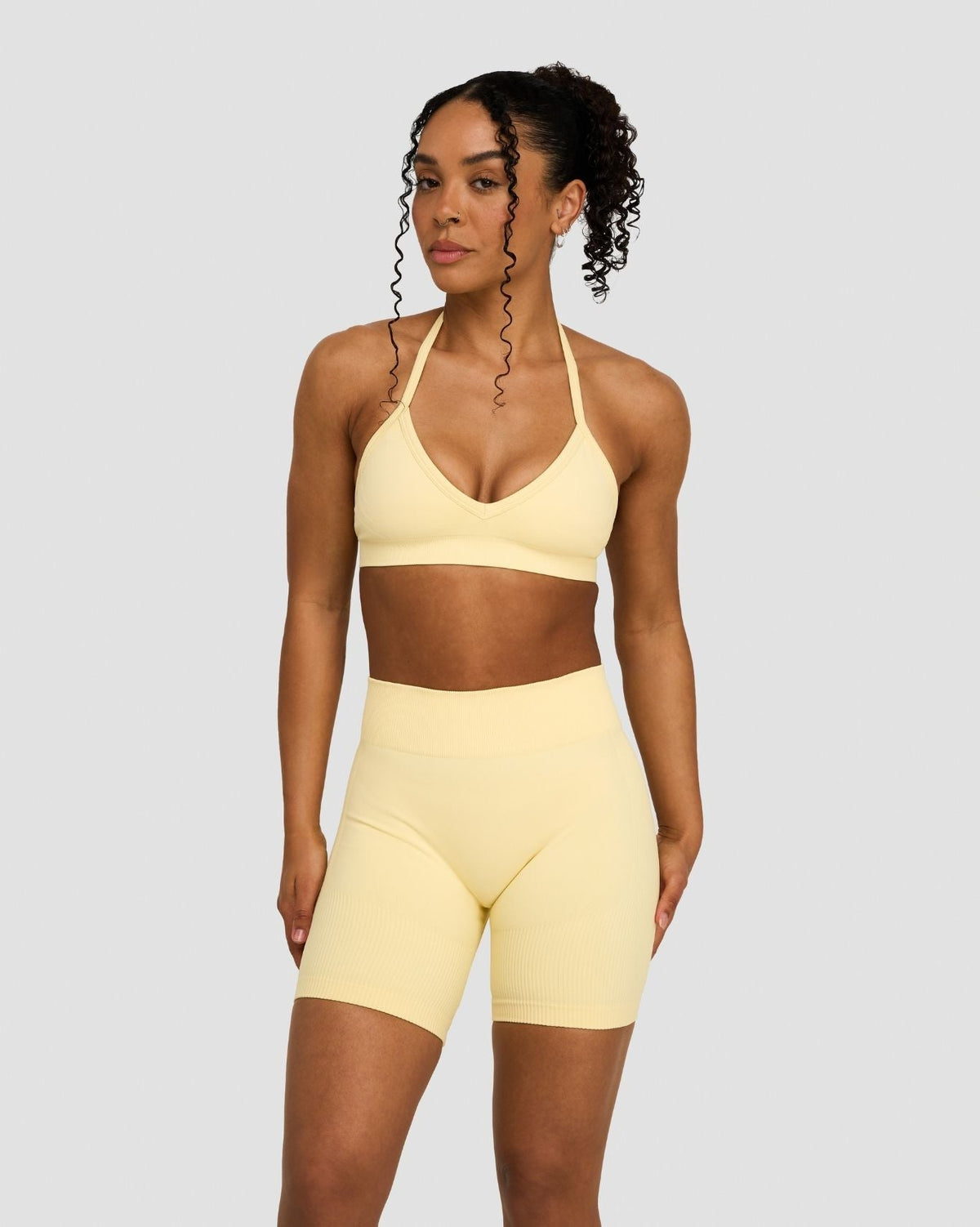 Elevate Sculpting Seamless Adjustable Halter Bra in Butter Yellow, front view styled with matching shorts