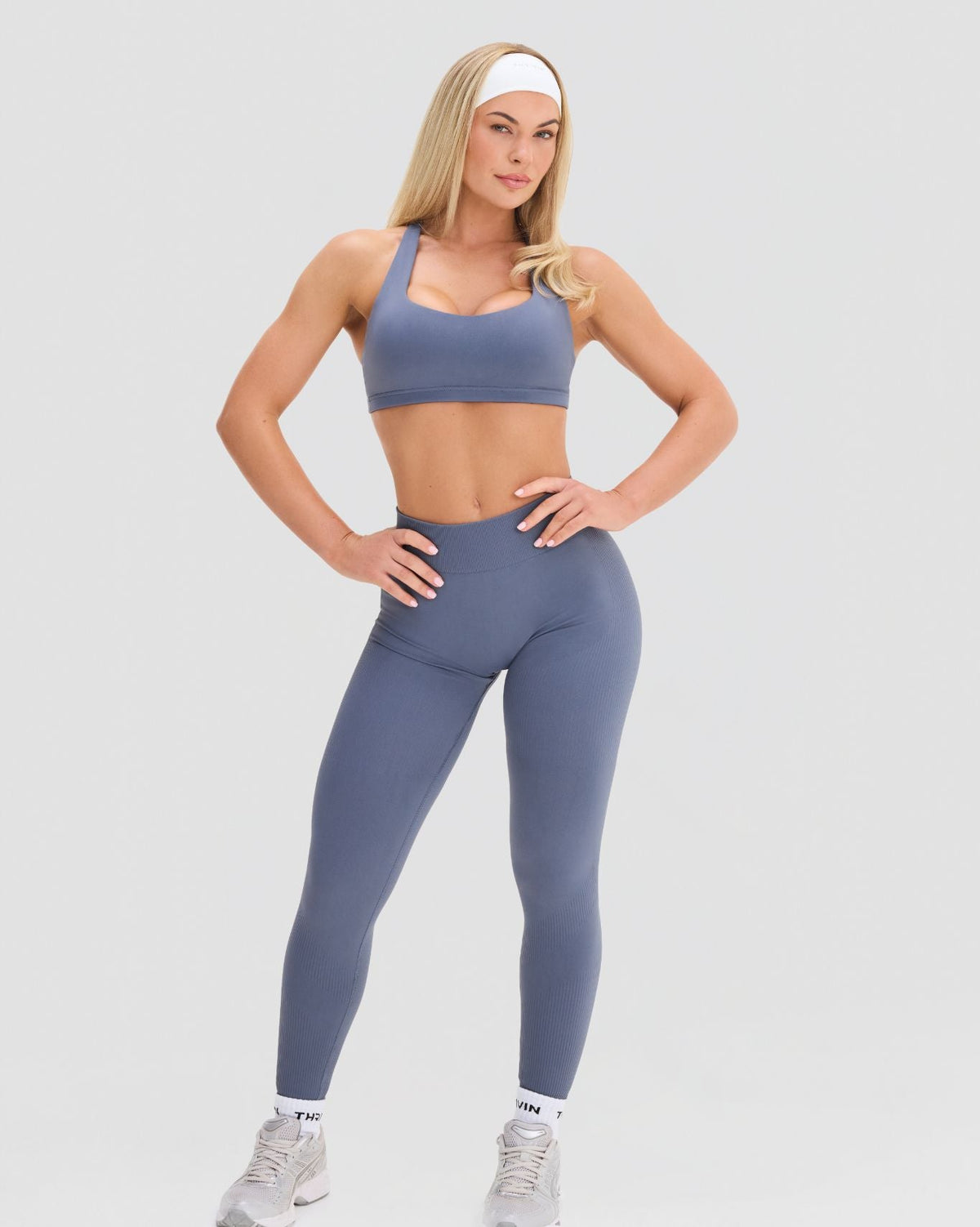 Elevate Sculpting Medium Impact Multiway Bra in Steel Blue, front view of scoop neckline and cropped fit above leggings