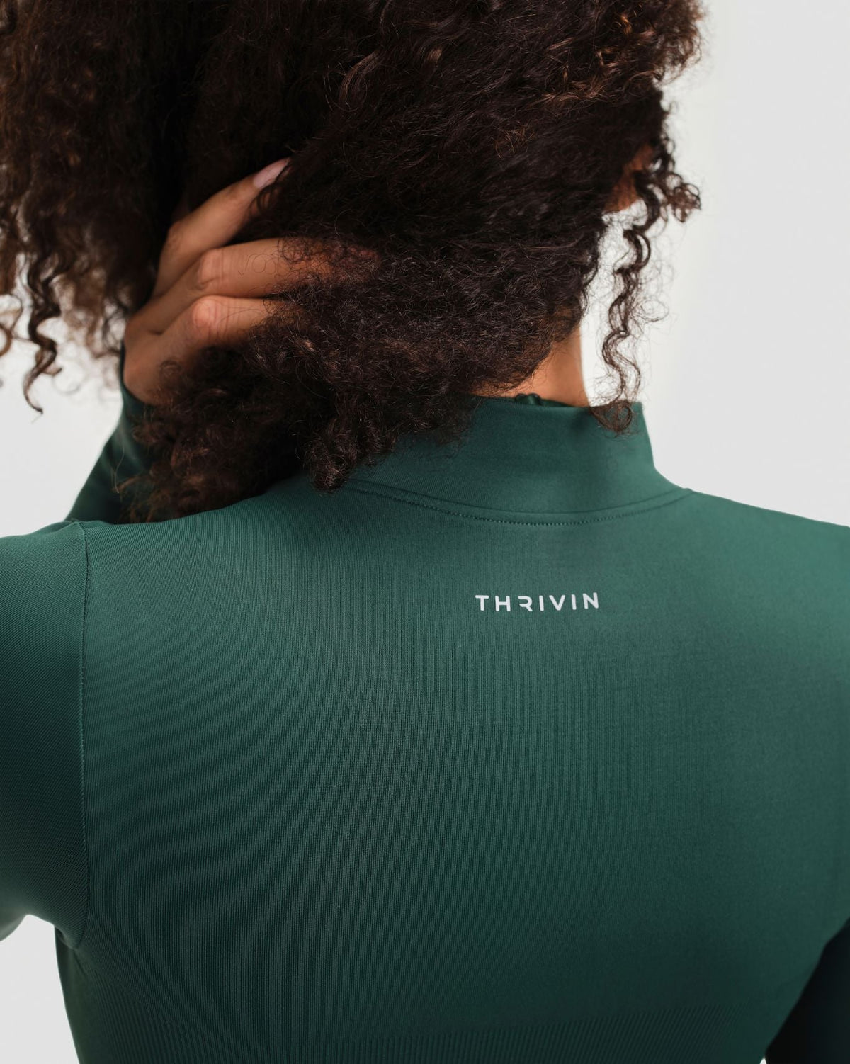 Elevate Compression Long Sleeve Jacket in Pine Green, back close-up of stand collar and Thrivin logo on smooth knit