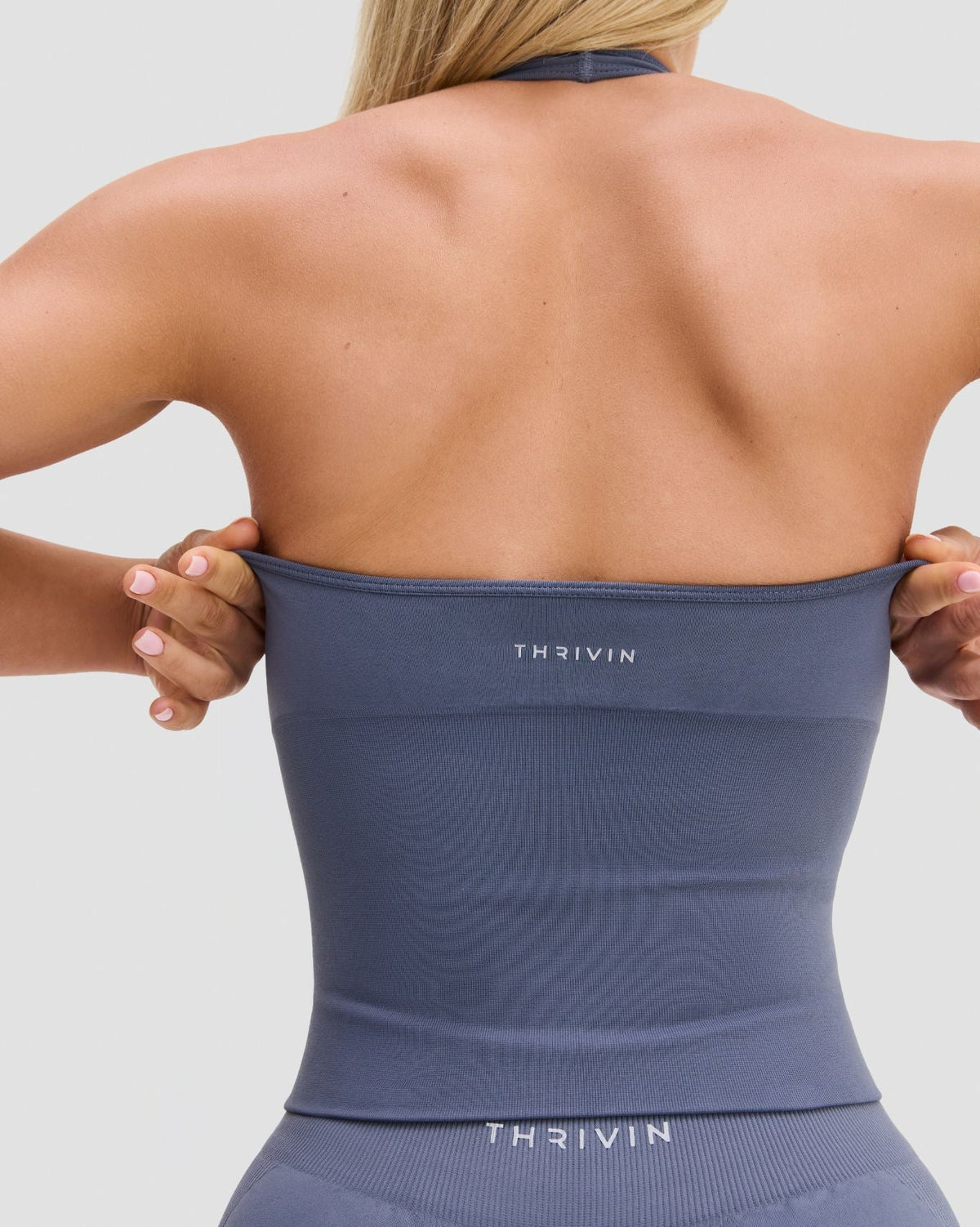 Elevate Sculpting Seamless Halterneck Top in Steel Blue, back close-up of the open back and Thrivin logo band showing stretch