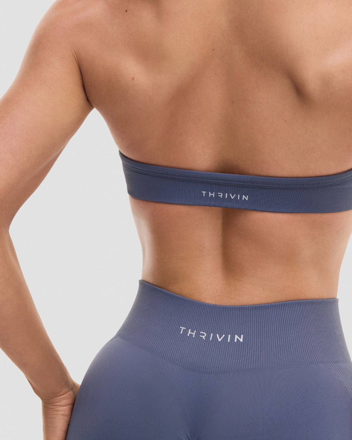 Elevate Sculpting Seamless Adjustable Halter Bra in Steel Blue, back close-up of low back band, Thrivin logo and smooth knit